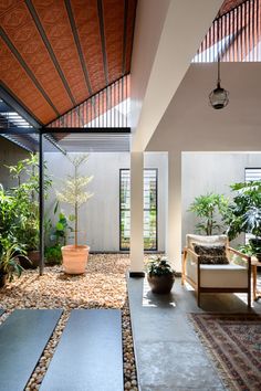 an indoor living room with plants and rocks on the floor