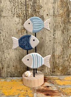 three blue and white fish sitting on top of a wooden stand