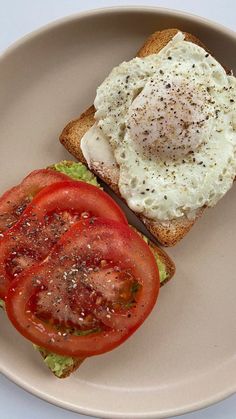 an egg and tomato sandwich is on a plate