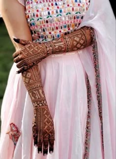 a close up of a woman's hands with hennap on her arm