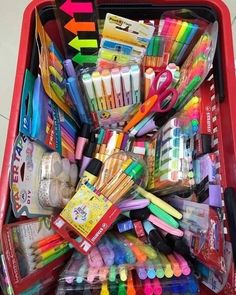 a red shopping cart filled with lots of school supplies