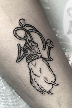 a tattoo on the leg of a person with an arrow and crown around his neck