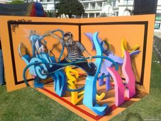 a man sitting on top of a colorful sign