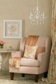 a living room with a chair, table and chandelier