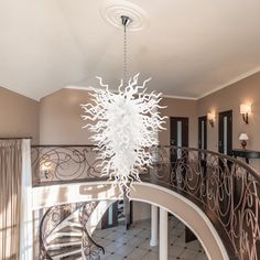 a chandelier hanging from the side of a spiral staircase