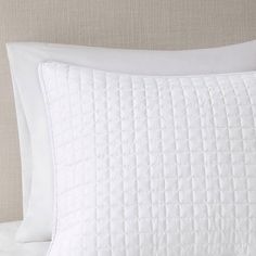 a close up of a white pillow on a bed