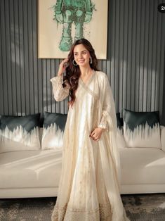 a woman standing in front of a white couch