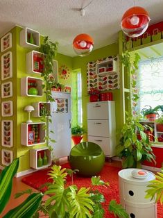 a room filled with lots of plants next to a white refrigerator freezer sitting on top of a red rug