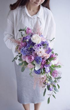 a woman holding a bouquet of flowers in her hands