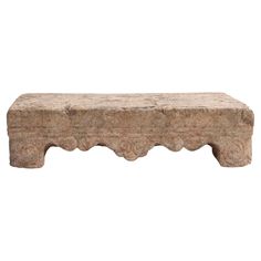 a stone bench with scalloped legs and an intricately carved design on the top