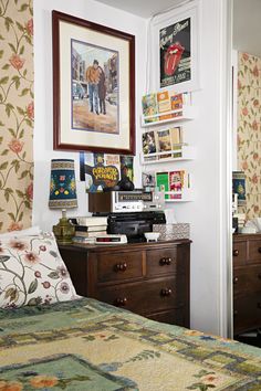 a bedroom with a bed, dresser and pictures on the wall