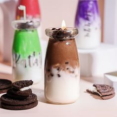 there are cookies and milk in the jar on the table next to each other,