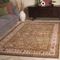 a living room area with a couch, coffee table and rugs on the floor