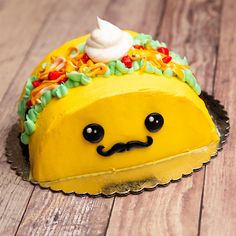 a cake shaped like a taco sitting on top of a wooden table