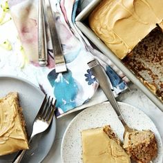 two plates with slices of cake on them next to forks and napkins, one has a fork in it