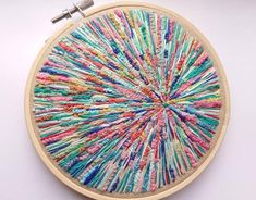 an embroidery project is displayed on a white surface with a thread spool in the center