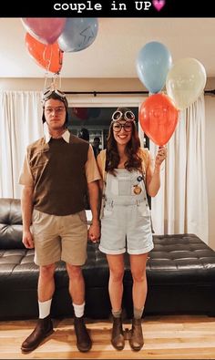 a man and woman standing next to each other with balloons attached to their heads in front of them