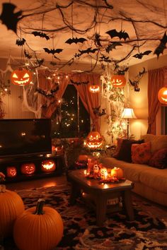 a living room decorated for halloween with pumpkins and bats hanging from the ceiling above