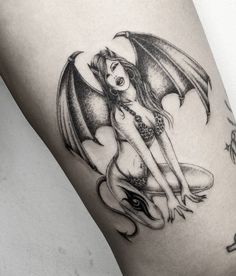 a woman with a dragon tattoo on her thigh