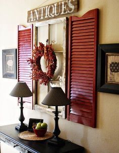 a living room with red shutters and a wreath hanging on the wall next to two lamps