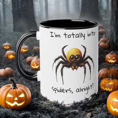 a coffee mug with a spider on it surrounded by pumpkins