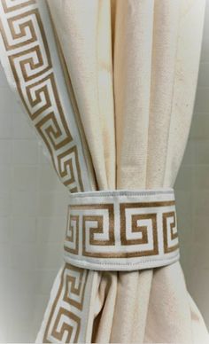 the curtain is decorated with greek designs on it's side and has a white border