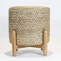 a woven basket sitting on top of a wooden stand