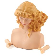 a doll with blonde hair sitting on the ground next to a white background and wearing a wig