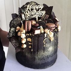 a birthday cake with chocolate, marshmallows and macaroons on it