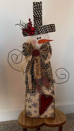 a snowman made out of fabric sitting on top of a wooden table next to a wall