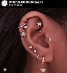 an ear with several different types of piercings on it, including stars and moon