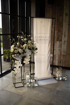 flowers and candles are on display in front of a sign