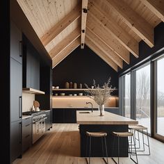 a kitchen with wooden ceilings and black cabinets