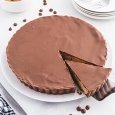 a chocolate cheesecake on a white plate with one slice missing