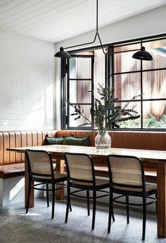 a dining room table with four chairs and a bench in front of it, next to a window