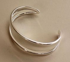 Georg Jensen Sterling Silver "Marcia" Cuff Bracelet by Vivianna Torun No. 618A   This series was inspired by Vivianna Torun's "Love Ring" and named after her daughter. This is the MEDIUM SIZE.   Medium 2.25" W x 1.15" H 1.15''  Opening Large 2.5" W x 1.75'' L x .88" H 1.38" W Opening Designer: Vivianna TorunMaker: Georg JensenDesign #: MarciaFactory NewDimensions: Various See AboveCountry of Origin: Thailand Diamond Carat Size, Haviland China, Shiny Bracelets, Diamond Bracelet Design, Silver Jewellery Indian, Classic Bracelets, Star Bracelet, Georg Jensen, Silver Jewelry Handmade