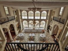 an overhead view of a large room with tables and chairs in the center, surrounded by arched windows