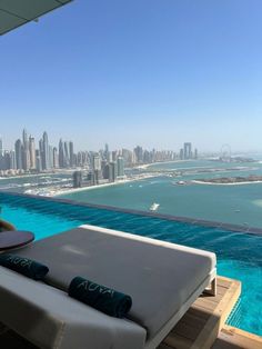 an outdoor pool overlooking the city skyline with blue water and boats in the bay area