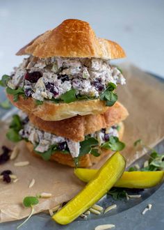 a chicken salad sandwich on a roll with pickles