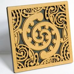 an intricately designed wooden plaque with the letter g in it's center, on a white background