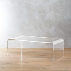 a glass table sitting on top of a hard wood floor