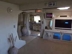 the interior of an rv with its door open and television in the living room area