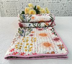 three quilted bedspreads with flowers on them sitting next to each other in front of a wall