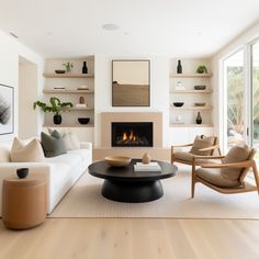 a living room filled with furniture and a fire place in the middle of the room