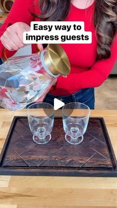 a woman pouring water into two glasses on top of a wooden table with the words easy way to impress guests