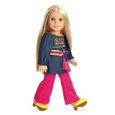 a doll with blonde hair wearing pink pants and a blue shirt is walking towards the camera