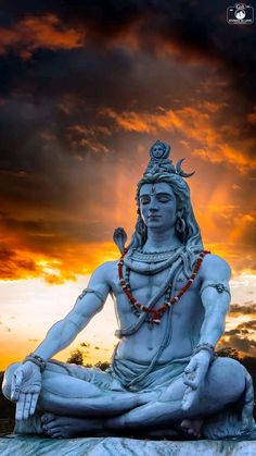 the statue is sitting in front of an orange and blue sky with clouds behind it