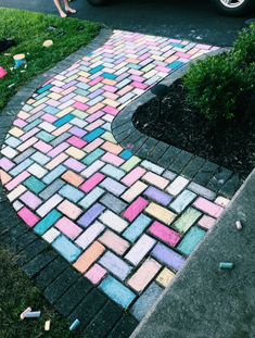 a sidewalk made out of colored bricks and crayons in front of a car