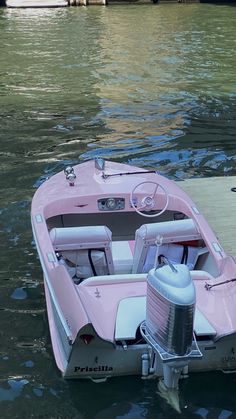 a pink boat floating on top of a body of water