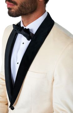 a man wearing a white suit and black bow tie